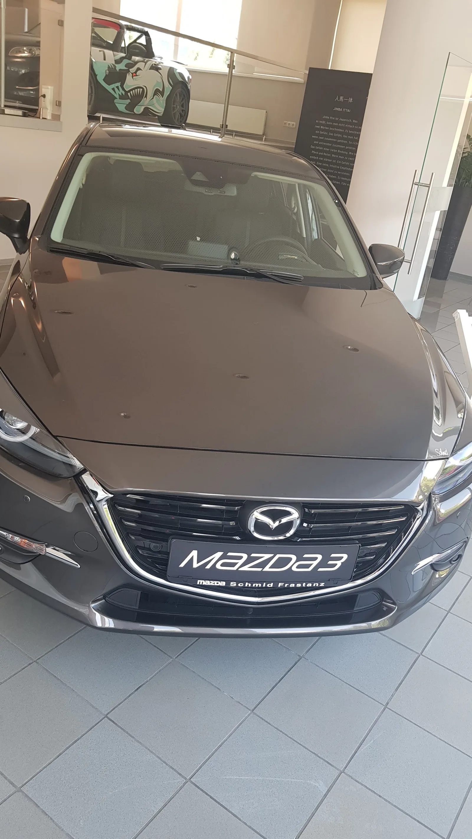 Ein Mazda3 im Schauraum, am Händlerkennzeichen steht Schmid Frastanz